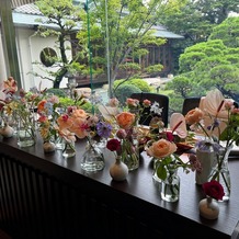 三瀧荘の画像｜メインテーブル装花と披露宴会場から見える庭園