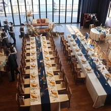 BAYSIDE GEIHINKAN VERANDA minatomiraiの画像｜シャンパンゴールドのテーブルクロスにネイビーのテーブルランナーで引き締めました。