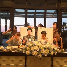 アイネス　ヴィラノッツェ　オーシャンポートサイドの画像｜友人との集合写真。新郎新婦の真ん中に大きな装花があります