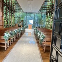 アクアガーデン迎賓館　岡崎の画像｜入場の景色。グリーンがたくさんでとても暖かみのある挙式会場。癒されるような空間。