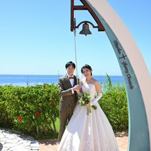 エリスリーナ西原ヒルズガーデンの画像｜快晴の空と読谷村の青い海の前で、結婚の誓いの証として鐘を鳴らしました