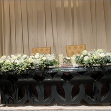 ホテル日航高知旭ロイヤルの画像｜高砂のテーブルは黒色にして、装花や衣装が引き立つよう意識。後ろのカーテンはホテルのものから選択。