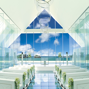 アイネス　ヴィラノッツェ　沖縄／クチュールナオコウエディング:上質感が漂う白い空間に、青い海や空、青のガラスのバージンロードが美しく映える