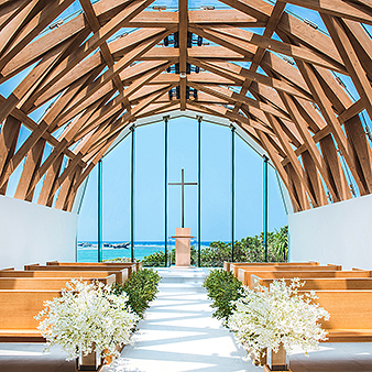 瀬良垣島教会／アールイズ・ウエディング:瀬良垣ブルーの海が一面に広がり、ウッド調の天蓋と青空がふたりを迎える
