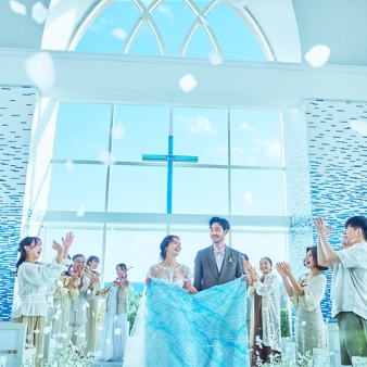 シギラ ミラージュチャペル／シギラセブンマイルズリゾート：◆グランドオープンフェア◆『60分で』クイックフェア：【今秋、人気チャペルがグランドリニューアル】宮古島屈指のリゾートに浸る滞在型Wを水平線まで見渡す海の眺めがどこまでも広がるチャペル。天井に煌く瑞々しい珊瑚色のオブジェやステンドグラスの透明感と相まって、まるで海の中に居るかのよう。ふたりの式を通して、ゲストに〈宮古島の海〉を五感で体感してもらえる。