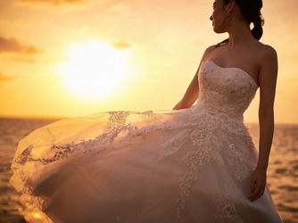 アートグレイス　オーシャンフロントガーデンチャペル　沖縄：夕日に照らされたドレスはお昼間とは違った輝きを放ちます